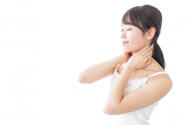 白いキャミソールを着た女性が目を閉じてリラックスしながら首をマッサージしている様子